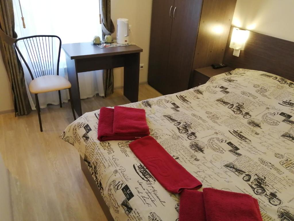 a bed sitting in a bedroom next to a dresser at Baker Street Hotel in Nizhny Novgorod
