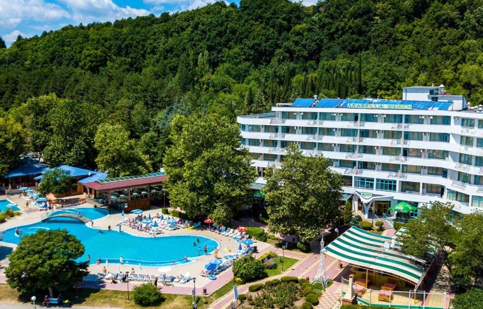 a hotel with a swimming pool in front of a mountain at Hotel Arabella Beach in Albena