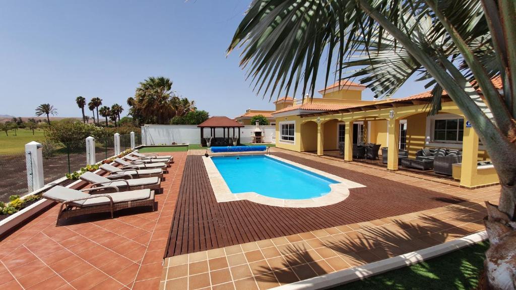 dom z basenem i leżakami w obiekcie Villa BONITA on Golf in El Descanso ,Caleta Fuste-Fuerteventura w mieście Caleta De Fuste