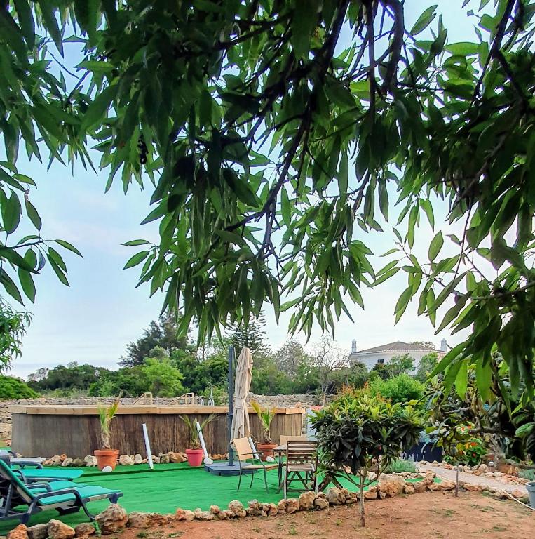 a yard with a green lawn with picnic tables and chairs at Hakuna matata in Benagil