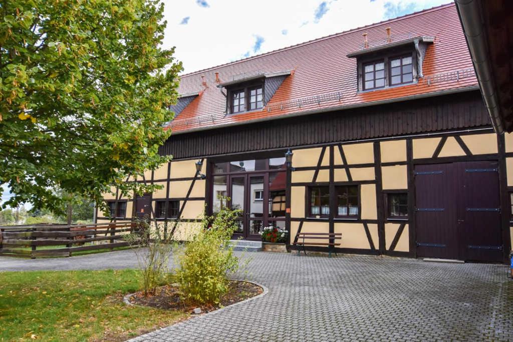 un gran edificio con una puerta y un árbol en Lavendelhof Die idyllische Landpension 