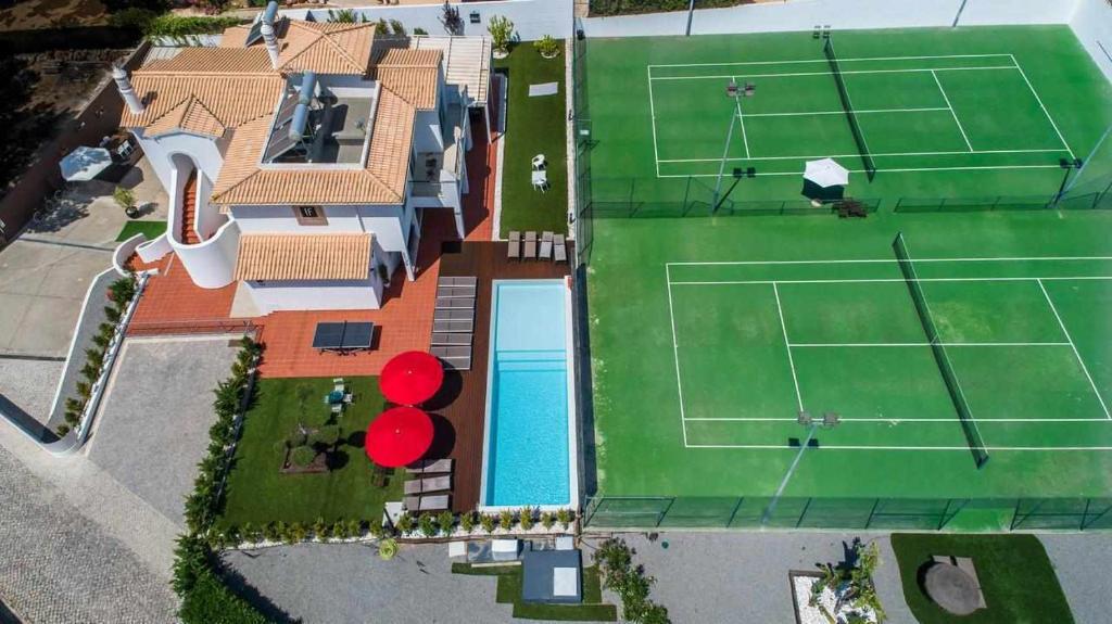 an aerial view of a house with a tennis court at Villa w Private Pool Tennis Courts e Golf Putt in Vilamoura