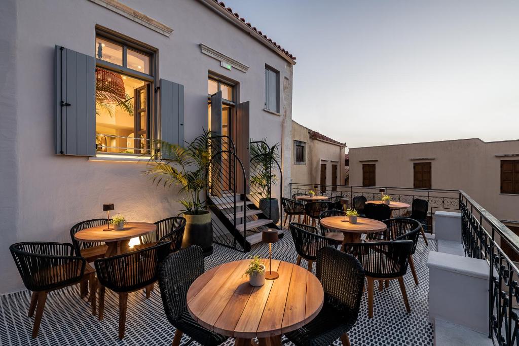 a patio with tables and chairs on a balcony at Malmo Historic Hotel in Chania Town