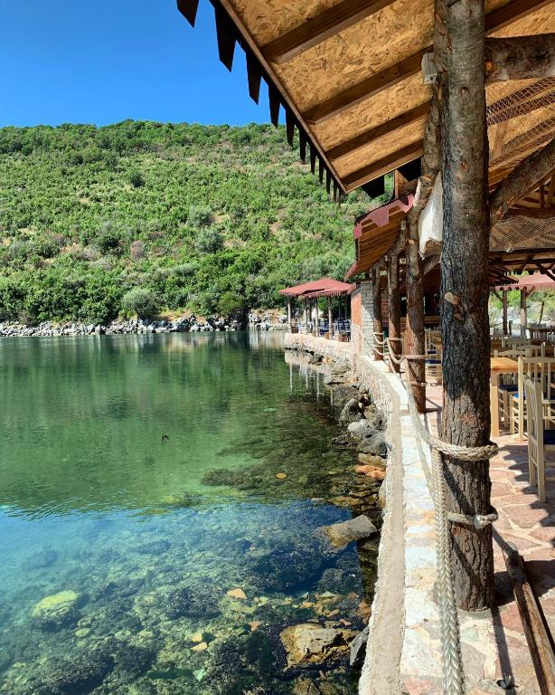 a building next to a body of water at The Mussel House in Ksamil