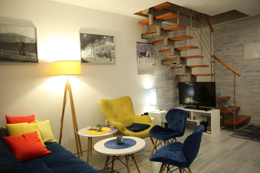 a living room with a blue couch and chairs at Apartament Dla Dwojga in Ustrzyki Dolne