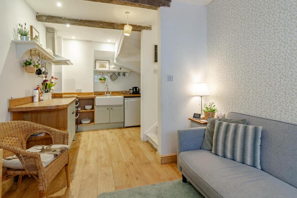 a living room with a couch and a kitchen at The Shoe Box cottage with allocated parking in Malmesbury
