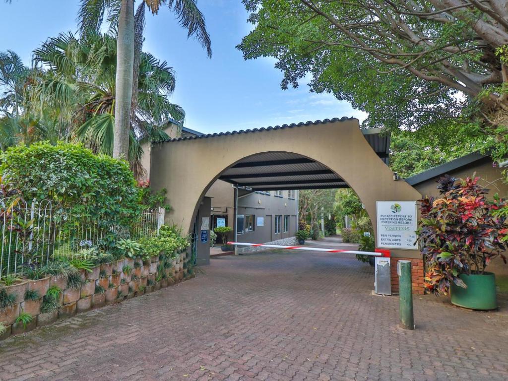 Illovo的住宿－Villa Spa Holiday Resort，拱门,通往树木和植物的建筑