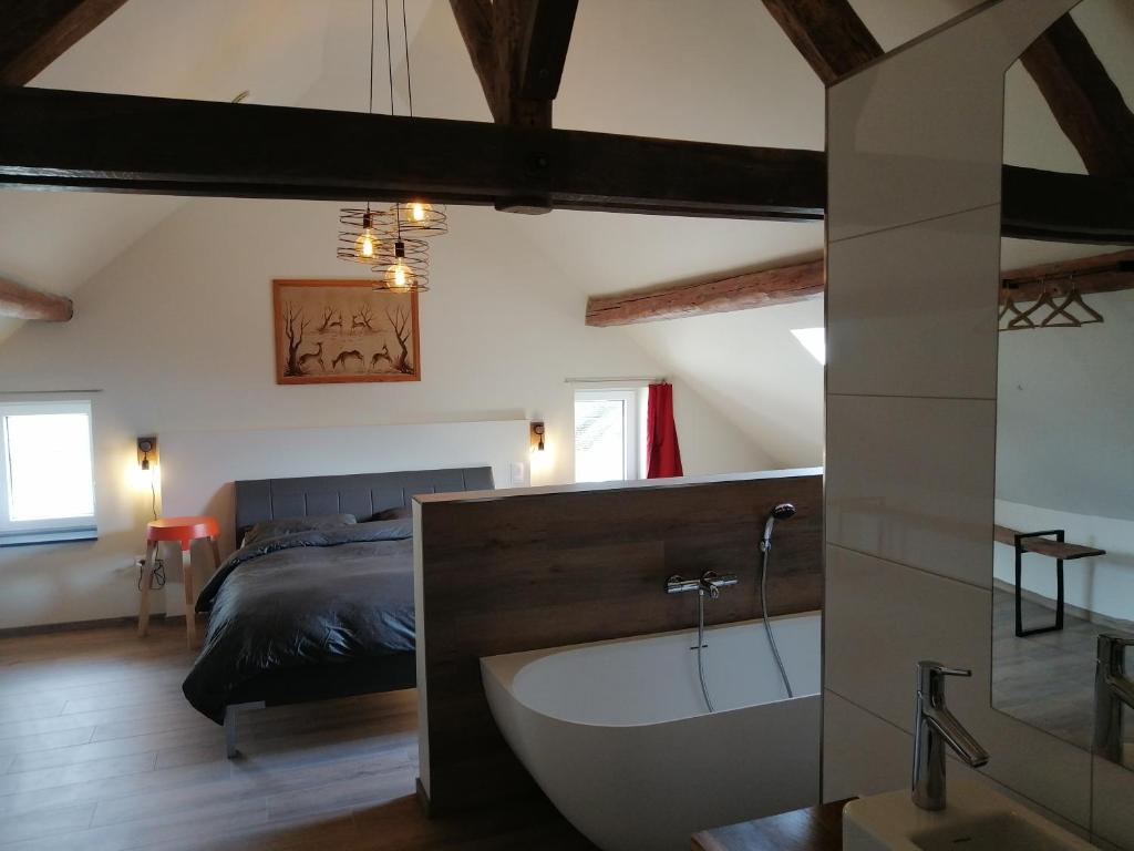 Schlafzimmer mit Badewanne und Bett in der Unterkunft de ploeg luxe in Büllingen
