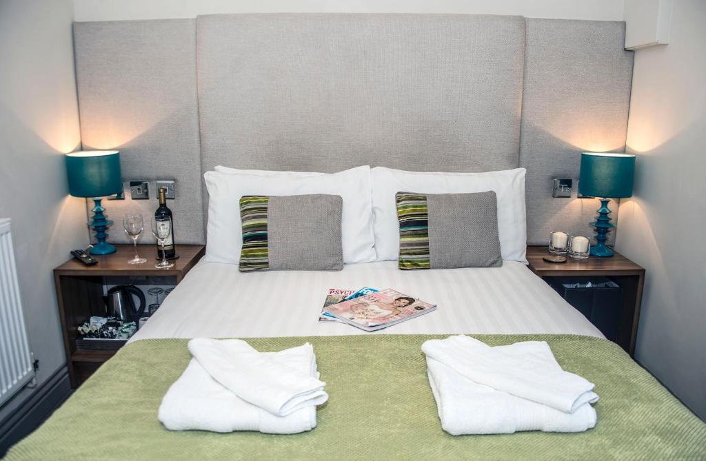 a bedroom with a bed with two pillows and two lamps at Book A Base - Chester - City Road in Chester