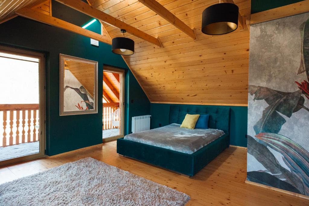 - une chambre avec un lit dans une pièce dotée de plafonds en bois dans l'établissement Domek Przy Strumyku, à Rajcza