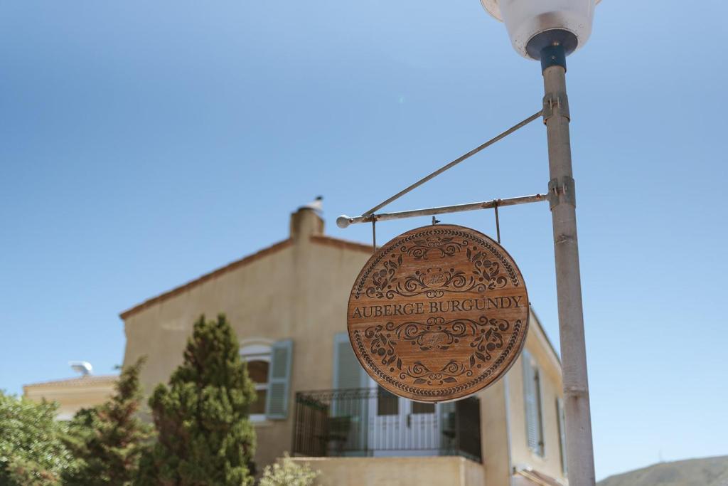 a sign hanging from a street light in front of a house at Auberge Burgundy Boutique Hotel & Spa in Hermanus