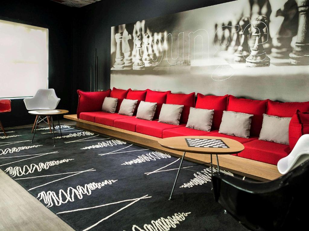 a red couch in a living room with a table at ibis Criciuma in Criciúma