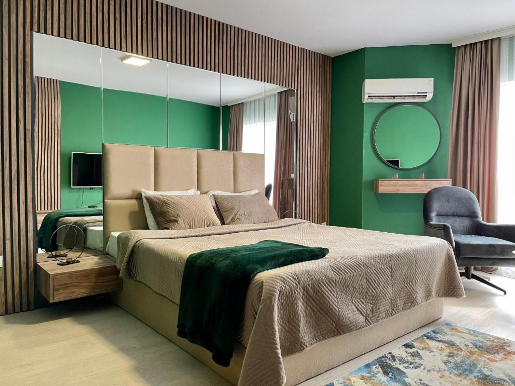 a bedroom with a large bed and a mirror at Downtown Apartments in Prishtinë