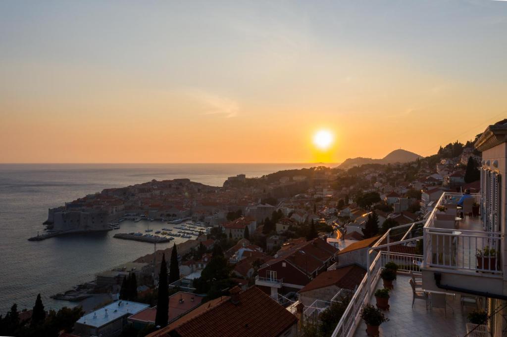 a city with the sun setting over the water at Rooms Raič in Dubrovnik