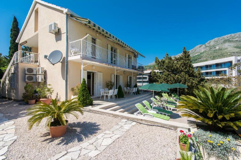 een huis met een patio met stoelen en planten bij Apartments & Rooms Jokovic in Mlini