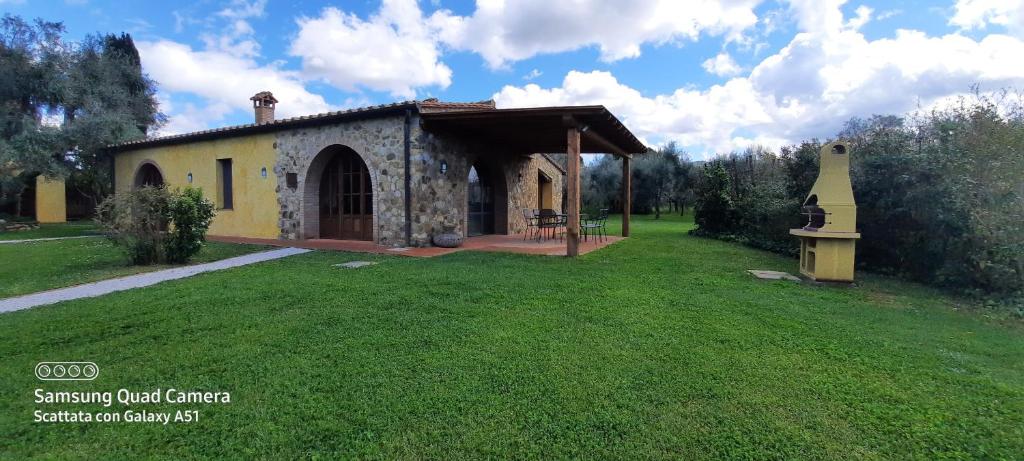 a small house in a field with a grass yard at Villa Lorenzo con wi-fi, aria condizionata, posto auto in Castagneto Carducci