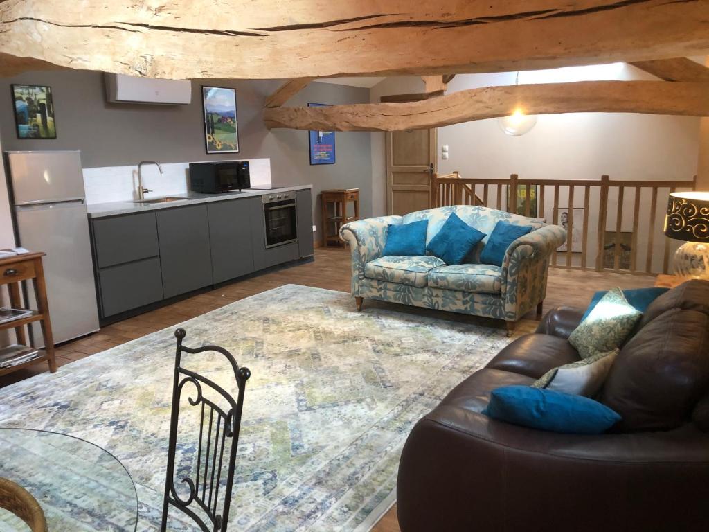 a living room with a couch and a kitchen at Maison Lamothe in Flamarens