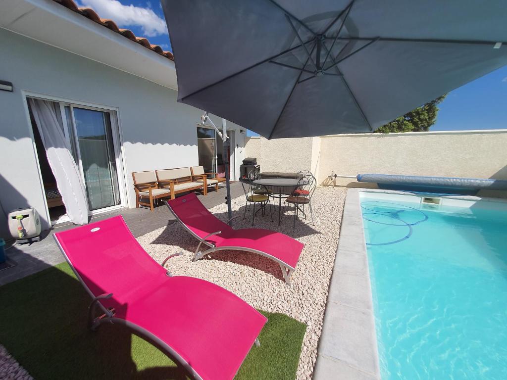 un patio con sillas rosas y una sombrilla junto a la piscina en Grempoup's Home, en Saint-Gély-du-Fesc