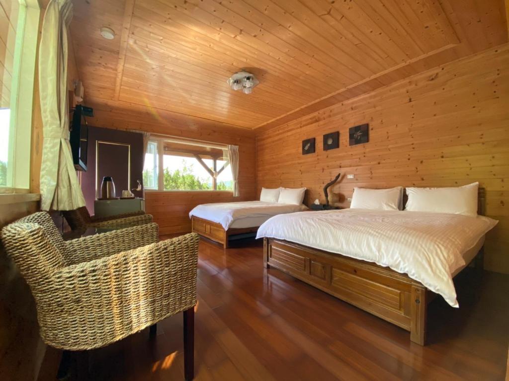 1 dormitorio con 2 camas en una habitación de madera en Lala Maple Villa, en Hualing