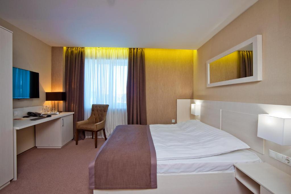 a hotel room with a bed and a desk at Premier Hotel in Krasnodar