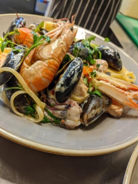 a plate of food with seafood on a table at Port Charlotte Hotel in Port Charlotte