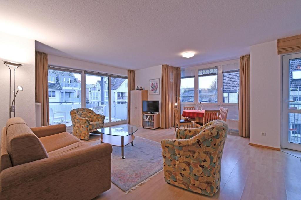 ein Wohnzimmer mit einem Sofa, Stühlen und einem Tisch in der Unterkunft BER/511 - Appartementresidenz in Scharbeutz