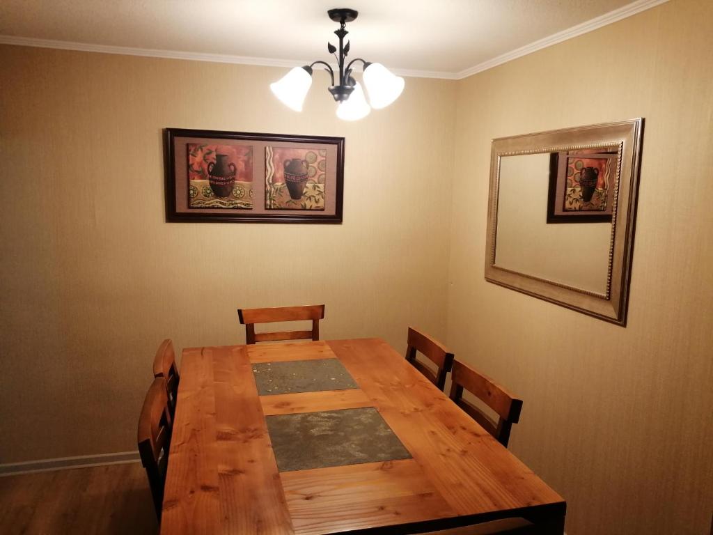 a dining room with a wooden table and chairs at Departamentos amoblados - Santa Sofia. in Concepción