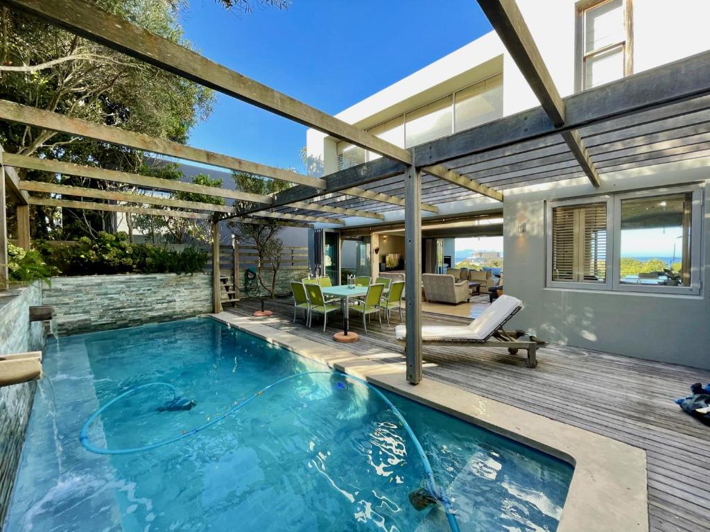 a house with a swimming pool and a patio at Beach End Plettenberg Bay in Plettenberg Bay