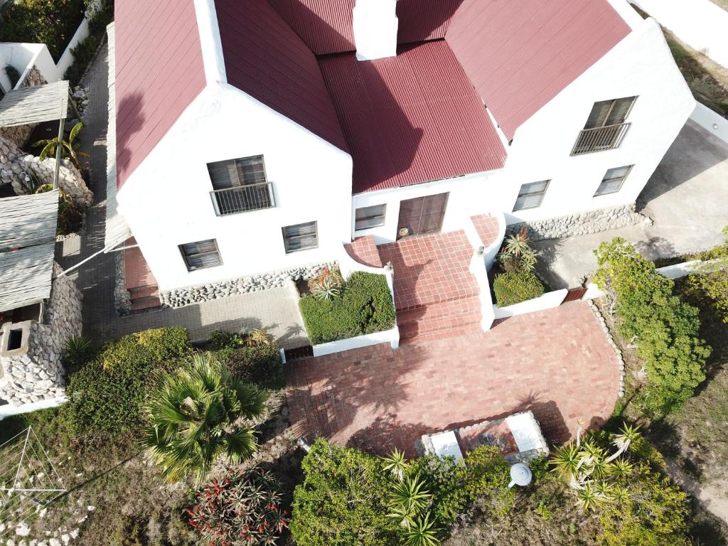 an overhead view of a white house with a red roof at Baviana Beach Lodge in Jacobs Bay