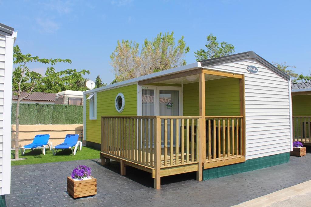 a green caravan with a porch and a deck at Camping Armanello in Benidorm