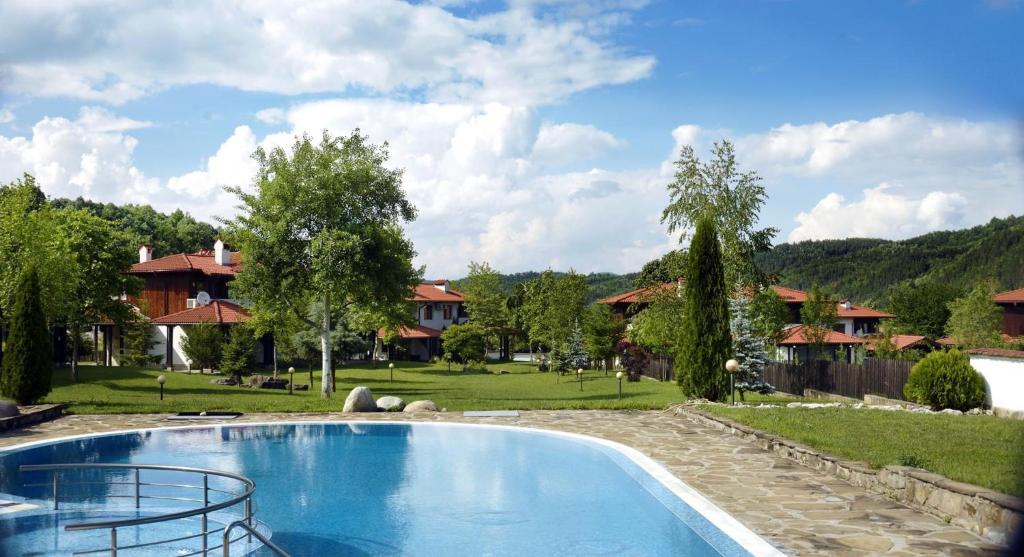 uma grande piscina num quintal com casas em Къща за гости Volpe - Volpe Guesthouse em Oreshak