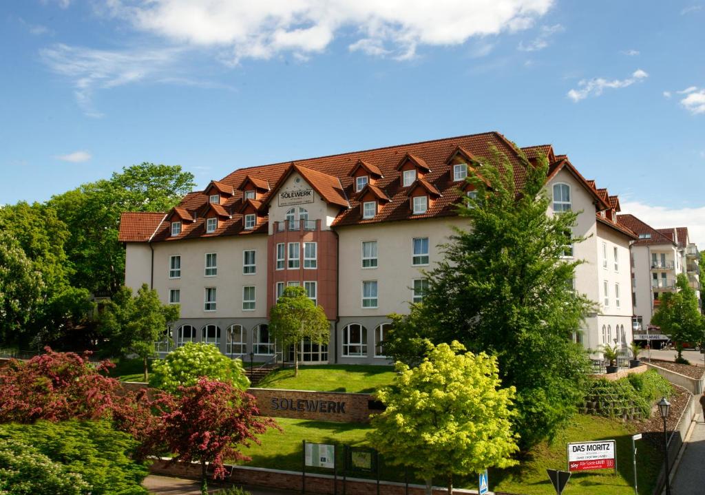 a large building with a red roof at SOLEWERK Hotel in Bad Salzungen