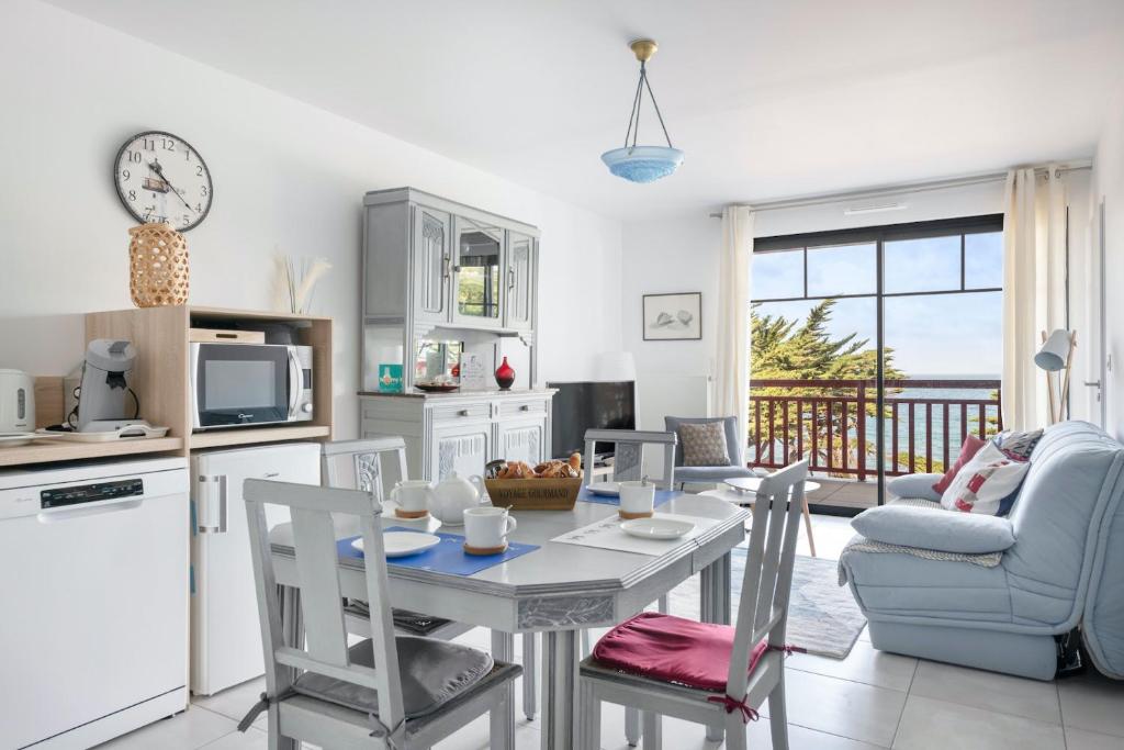 eine Küche und ein Wohnzimmer mit einem Tisch und Stühlen in der Unterkunft Esprit villa balneaire sur la cote bretonne pour trois personnes in Pléneuf-Val-André