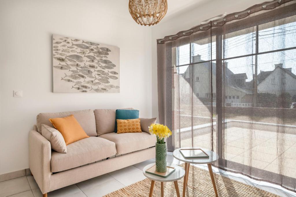 un salon avec un canapé et une fenêtre dans l'établissement À 50m de la plage, bel appartement pour 6, à Pléneuf-Val-André