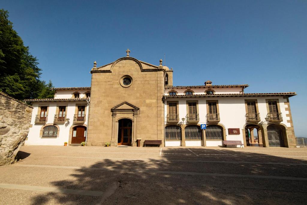 een groot bakstenen gebouw met een grote deuropening bij Santuari de la Salut de Sant Feliu de Pallerols in Sant Felíu de Pallarols