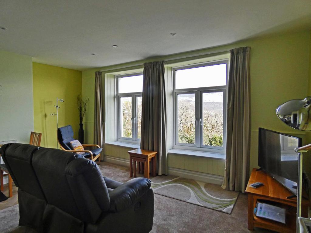 a living room with a couch and a television at Bryn Melyn Apartments in Barmouth