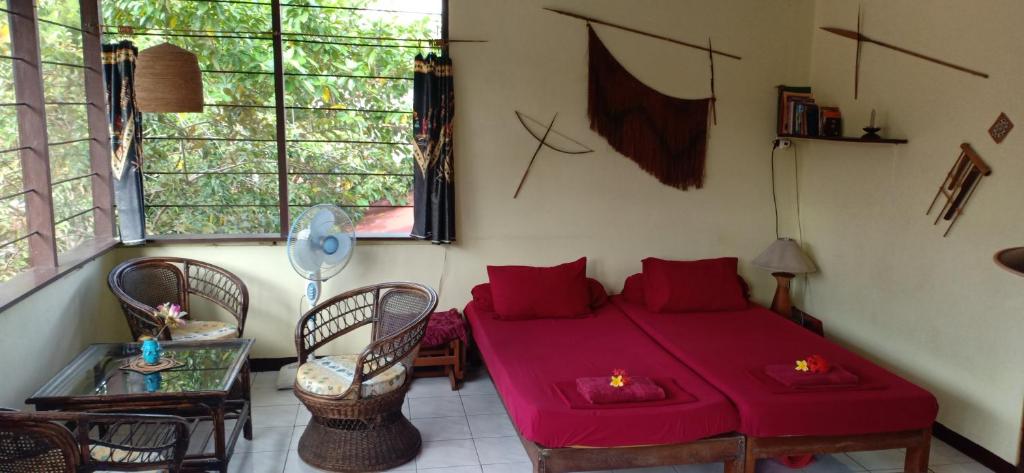 a living room with a red couch and a table at Homestay Galpera Papua in Jayapura