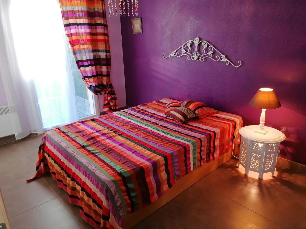 - une chambre avec un lit doté d'une couverture colorée et d'une lampe dans l'établissement LE SAINT FLORENT, à Oletta