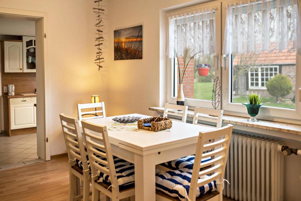 a kitchen and dining room with a table and chairs at Fewo-llojan in Wiesmoor