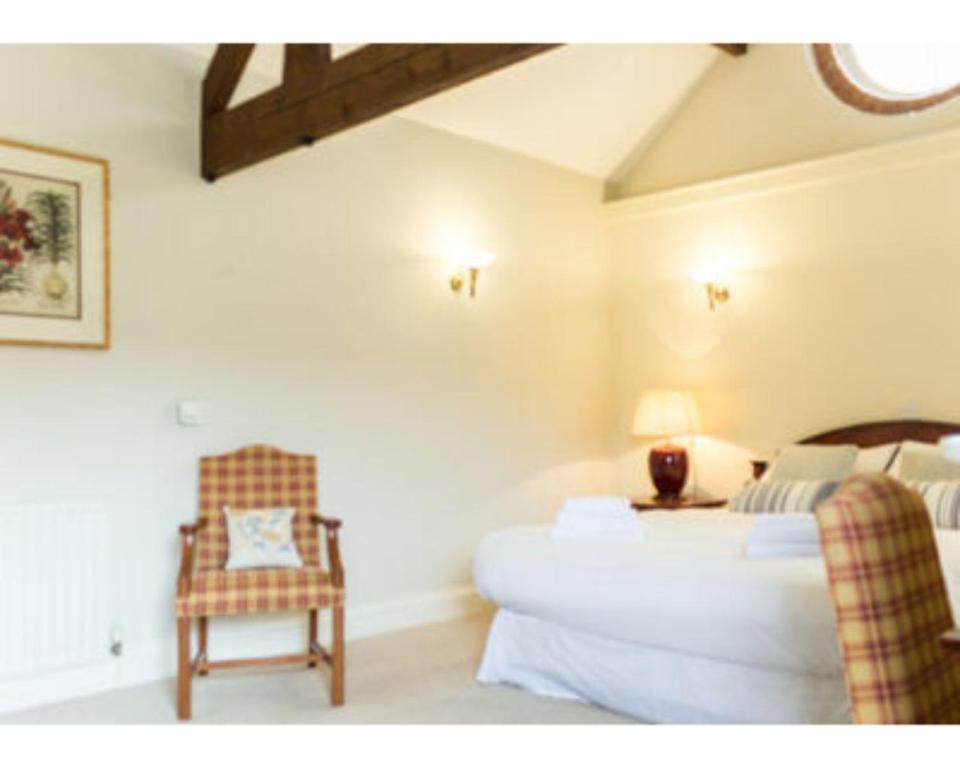 een slaapkamer met een bed en een stoel in een kamer bij The Bull Inn in Bourne