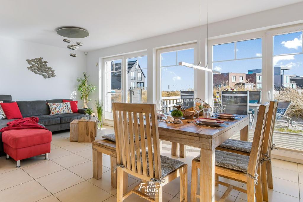 ein Wohnzimmer mit einem Tisch, Stühlen und einem Sofa in der Unterkunft Strandblick in Olpenitz