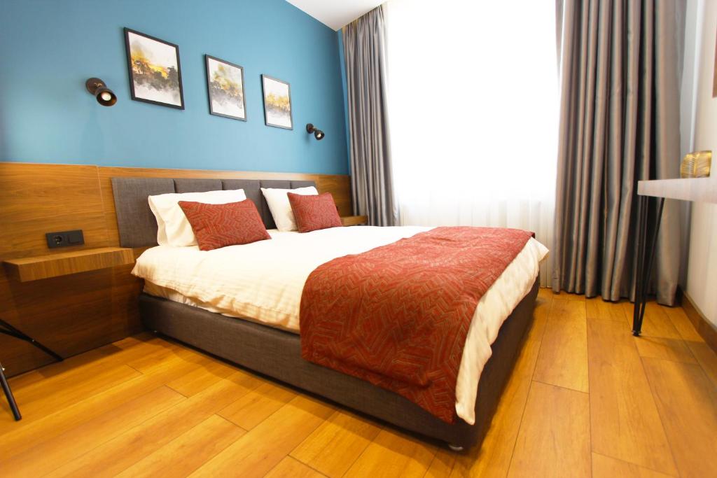 um quarto com uma cama grande e uma parede azul em Beşiktas konuk otel em Istambul