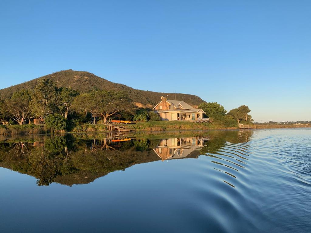 a house on the shore of a body of water at Moonriver Self Catering in Plettenberg Bay