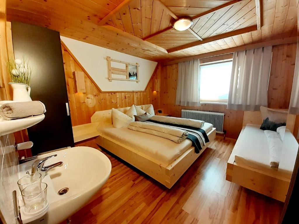 1 dormitorio con 1 cama y lavamanos en una habitación en Apart ZIRMZEIT en Huben