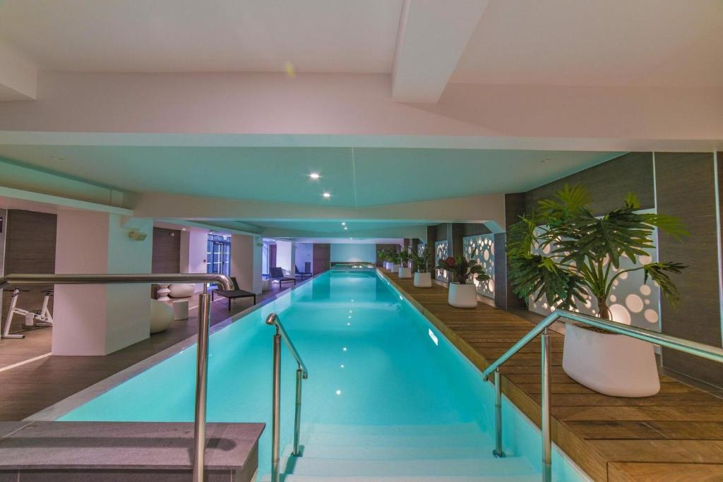 a swimming pool in a hotel with a building at Les Jardins de St Cloud in Saint-Cloud