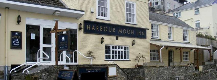 Una posada lunar marrón con un cartel delante de ella en The Harbour Moon en Looe