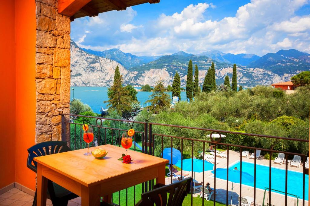 a balcony with a table and a view of a pool at Hotel Villa Isabella in Brenzone sul Garda