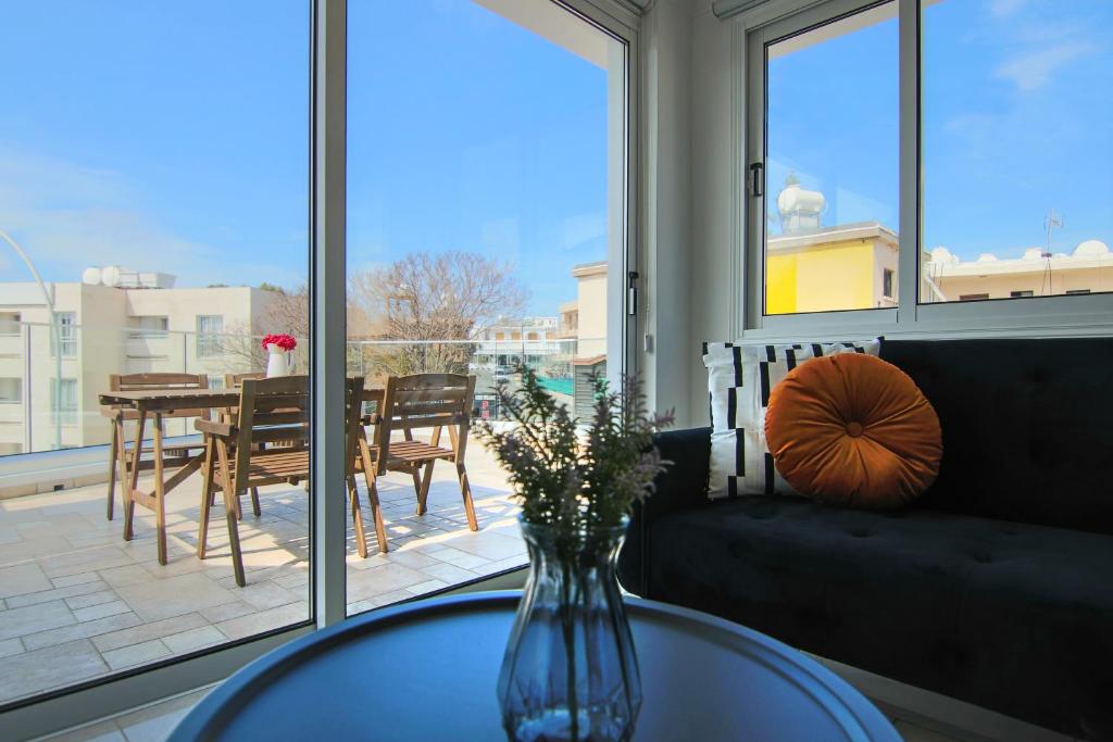 Un jarrón con flores sobre una mesa en una sala de estar. en Phaedrus Living: Seaside Modern Flat Lighthouse 63, en Pafos
