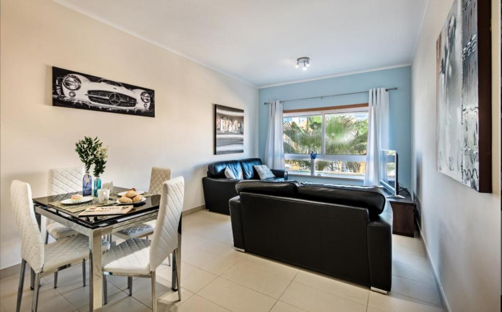 un salon avec un canapé noir et une table dans l'établissement Penthouse Apartment Royal Cabanas Resort, à Cabanas de Tavira