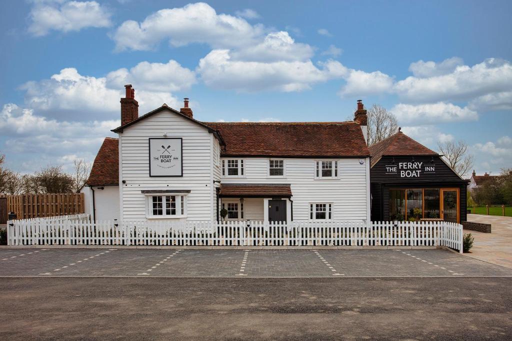 a white building with a white fence in front of it at The Ferry Boat Inn in North Fambridge